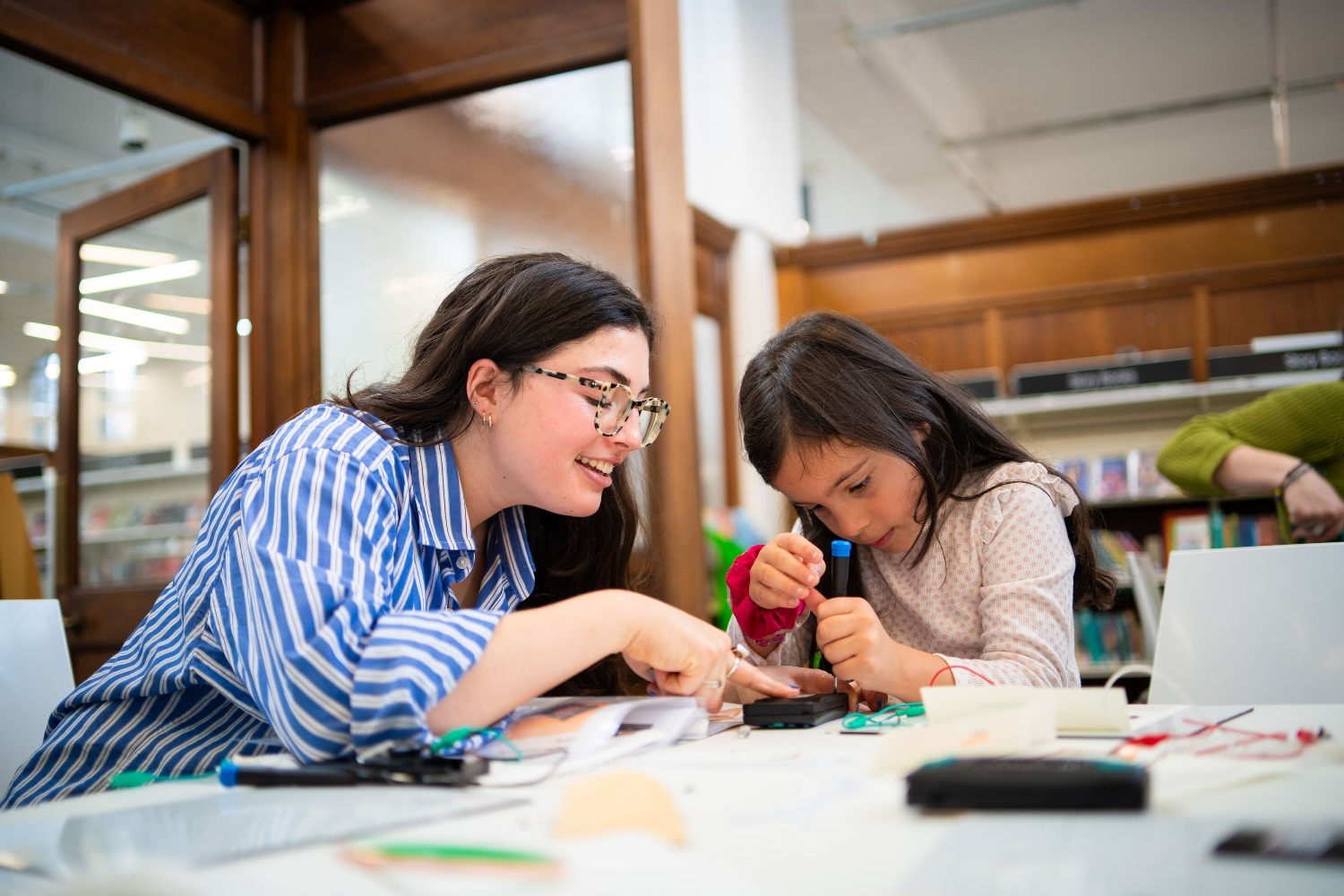 An adult and child repairing an electronic device