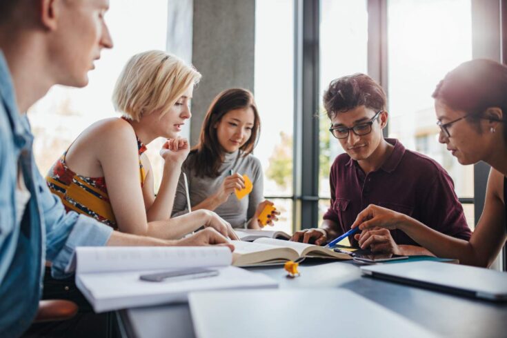 Group of students, sitting together and working on a project.