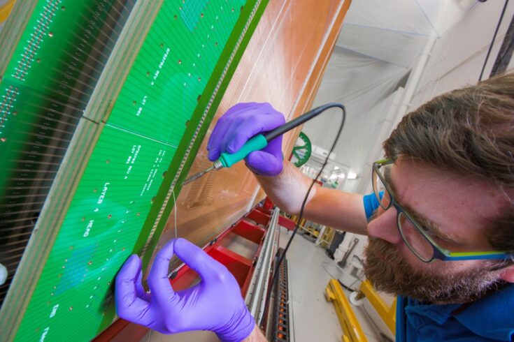 Engineer working on the DUNE project. Soldering the delicate wire is a precision job, done by hand.  